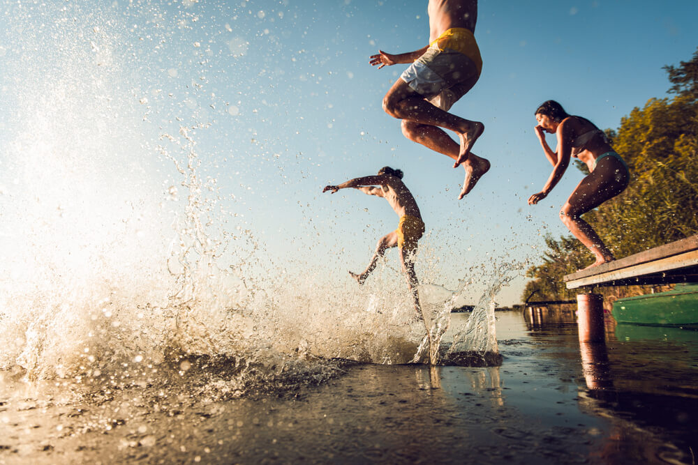 Guide to the Best Lake Activities in Innsbrook: A group of friends jumping off the dock into the lake